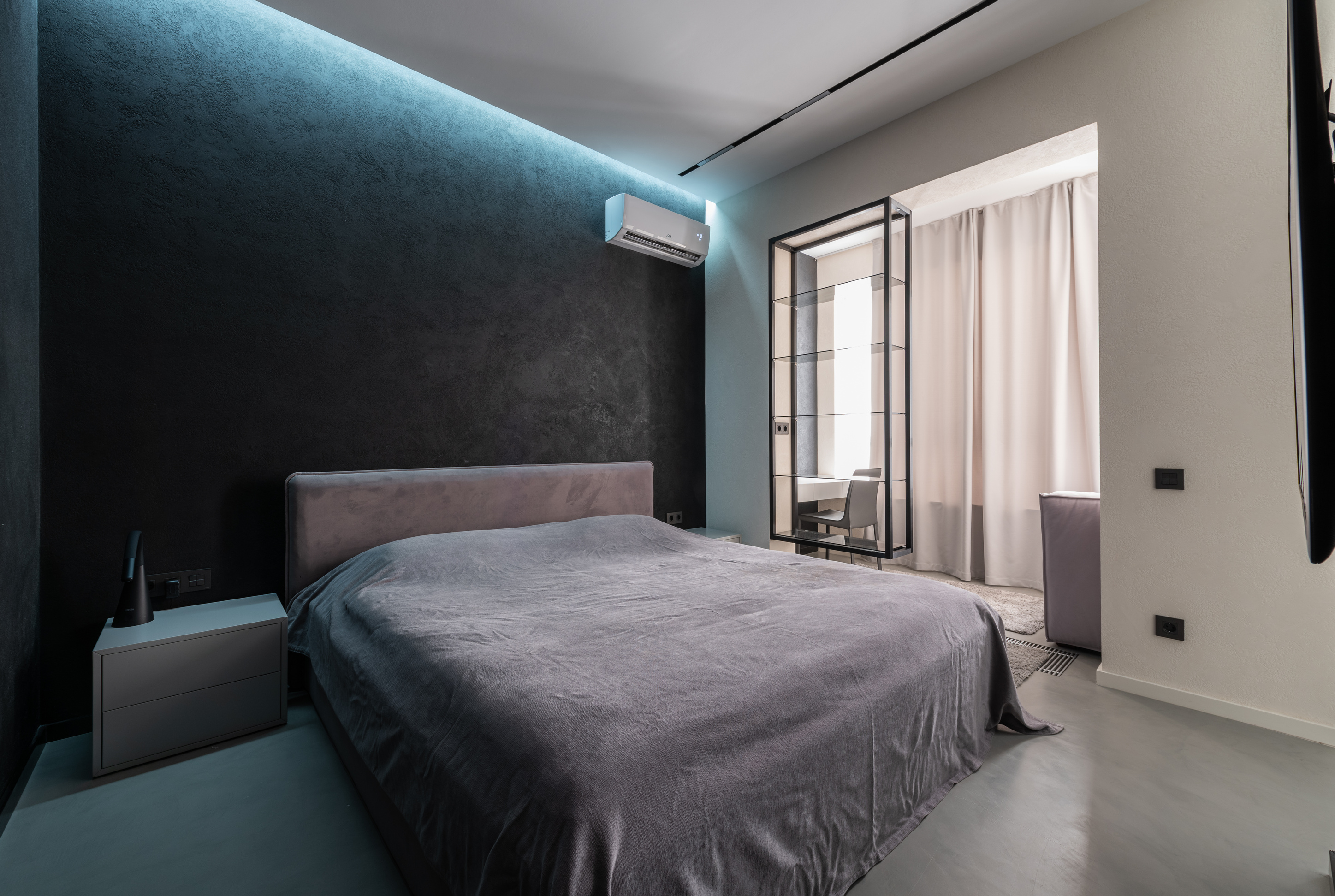 Made bed in spacious bedroom with air conditioner